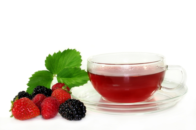 Fruit tea with berries next to a cup