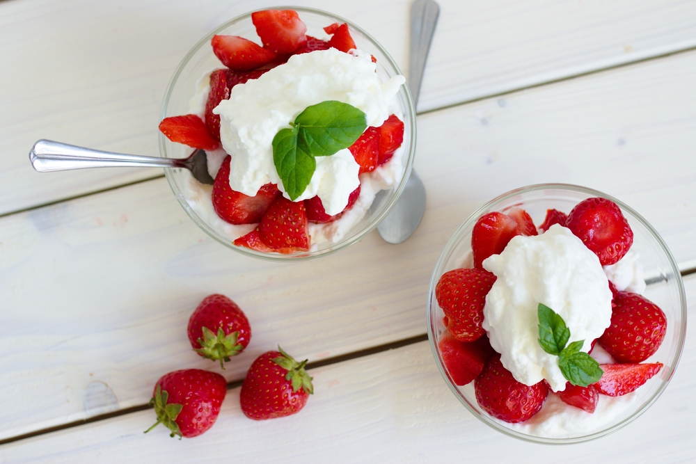 Two bowls of strawberries and cream